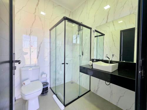 a bathroom with a glass shower and a toilet at Novissima casa com piscina proximo do Centro de Foz in Foz do Iguaçu
