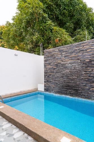 a blue swimming pool next to a brick wall at Casa Hermosa Privada in Salinas
