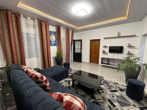 een woonkamer met een blauwe bank en een tv bij Tivana in Kigali
