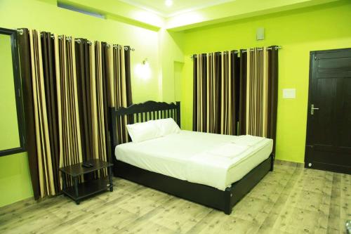a bedroom with a bed in a room with yellow walls at The Kissing Mountains in Vagamon