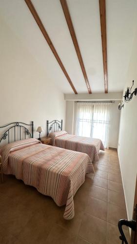 a room with two beds with striped sheets on them at Apartamentos Cuesta de la Cruz in Caravaca de la Cruz