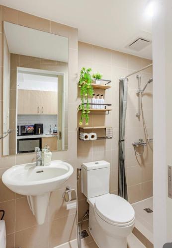a bathroom with a toilet and a sink and a shower at L Studio by Sella in Manila