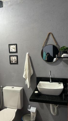 a bathroom with a sink and a toilet and a mirror at Ecoville Coracao da Serra in Areia