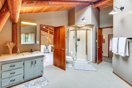 a bathroom with a shower and a toilet and a sink at Lake Margaret Access Boho Log Cabin with Backyard in Duvall