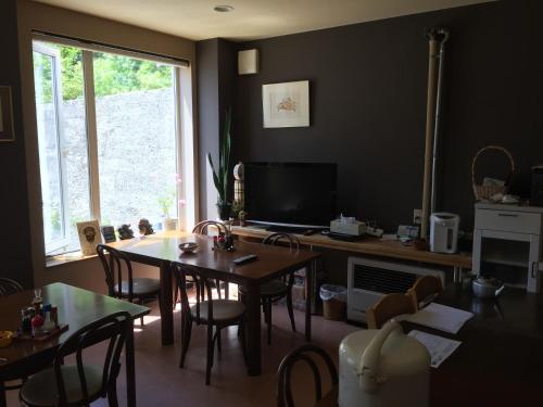 a dining room with a table and chairs and a television at Ryokan Yamaichi in Wakkanai