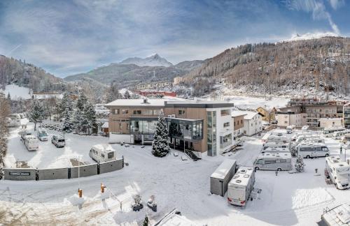 a town in the snow with buildings and cars at Camping Sölden Apartments in Sölden