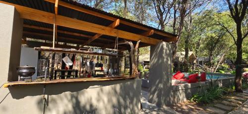 a outdoor bar with a wooden roof on a patio at Tot Hier Toe in Phalaborwa