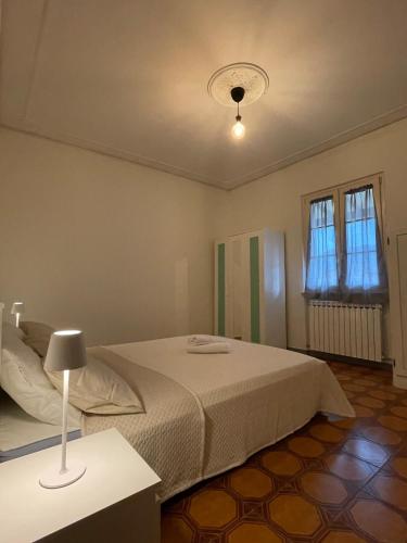 ルッカにあるCasa del Lamponeのベッドとランプ付きのテーブルがある寝室