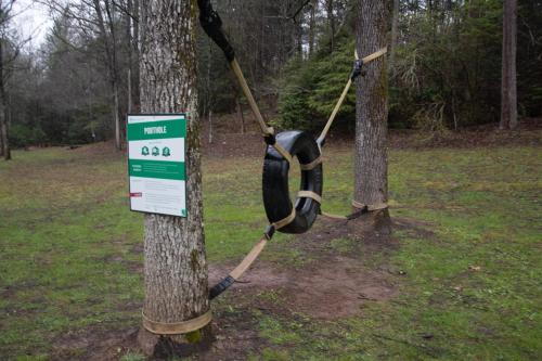 a rope tied to a tree with a sign on it at Project Chimps Historic Cabin in Morganton