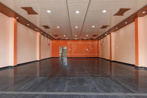 an empty room with an orange wall and an empty floor at SPOT ON SHREE JI HOTEL AND RESTAURANT in Lonavala