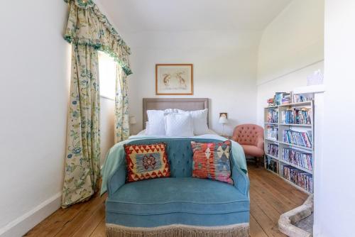 a bedroom with a blue bed and a book shelf at The Coach House at Kingsettle Stud in Cholderton