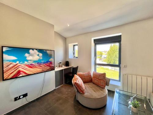 a living room with a large flat screen tv at T2 cosy avec parking à 15 min de Lyon in Pierre-Bénite