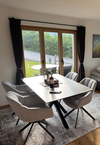 a dining room with a large white table and chairs at Chalet Schneelöwe in Bettelried