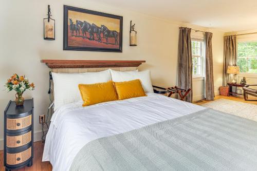 a bedroom with a large white bed with orange pillows at Burlington Escape By Lake Champlain and Bike Path in Starr Farm Beach