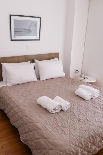 a bed with white pillows and two towels on it at TripoliStay in Tripoli