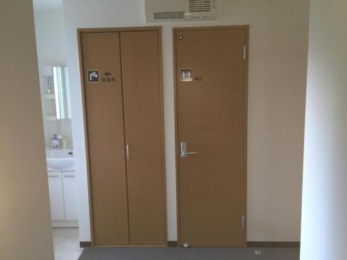 two lockers in a bathroom with a sink at Ryokan Yamaichi in Wakkanai