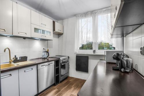 kuchnia z białymi szafkami i blatem ze stali nierdzewnej w obiekcie B&B wroclaw we Wrocławiu