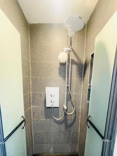 une douche avec pommeau de douche dans une salle de bain dans l'établissement Modern two bedroom home in the heart of Dundalk, à Dundalk
