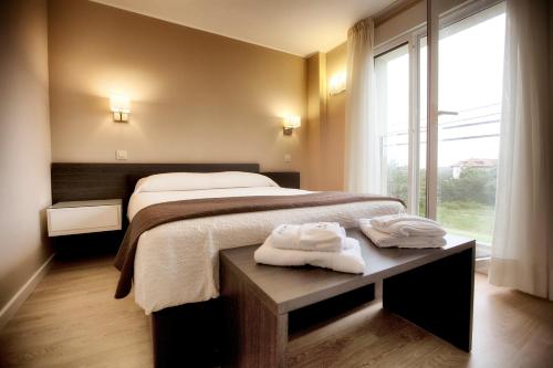 バロ・デ・リャネスにあるApartamentos Áncoraのベッドルーム1室(ベッド1台、テーブル、タオル付)