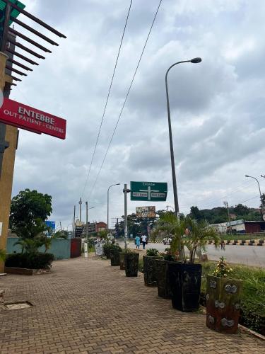 a street with street signs and plants on a sidewalk at 1 minute walk to Victoria Mall in Entebbe