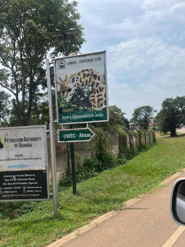a sign on the side of a road at 1 minute walk to Victoria Mall in Entebbe