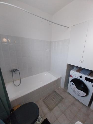 a white bathroom with a tub and a stove at Karamaniko in Episkopí