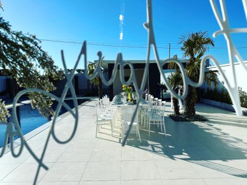 a table set up for a wedding with white chairs at La Mirage Villa in Rrushkull