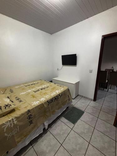 a bedroom with a bed and a tv on a wall at Microcasa 01 in Tangara da Serra