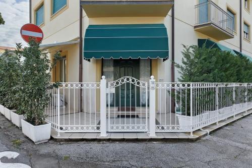 a white fence in front of a house at Appartamento Carducci 213 in Marina di Pietrasanta