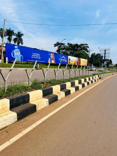 a road with a fence next to a street with a train at Hidden beautiful Modern Apartment in Entebbe