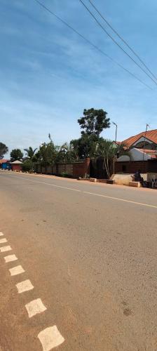 an empty road in a town with trees and buildings at Hidden beautiful Modern Apartment in Entebbe