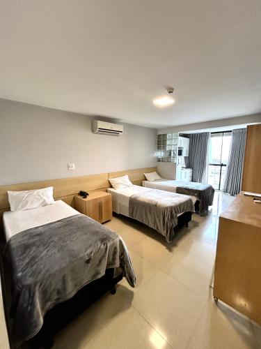 a hotel room with two beds and a kitchen at Flats em Brasília no Garvey Park Hotel in Brasília