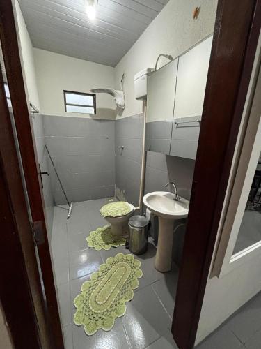 a small bathroom with a toilet and a sink at Microcasa 02 in Tangara da Serra