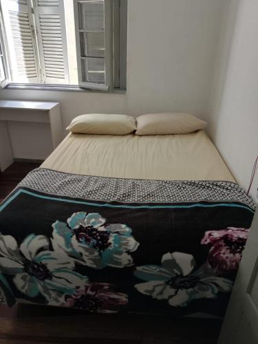 a bed with a blanket on it in a bedroom at Hostel Bahia POA Próx Shopping Total, Rodoviária e Hospital Presidente Vargas in Porto Alegre