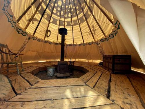 an inside of a tent with a wood stove at Authentic Tipi Set in the Stunning Woodland of the White Mountain National Forest, New Hampshire in Chatham