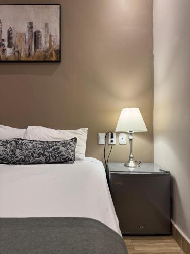 a bedroom with a bed and a lamp on a nightstand at Casa Roman Hotel Boutique in Cartagena de Indias