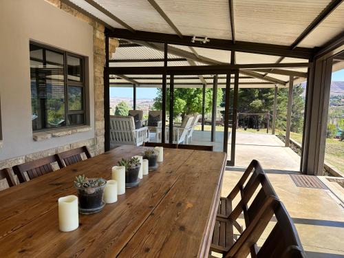 a large wooden table in a house with a patio at Clarens Old Clubhouse in Clarens
