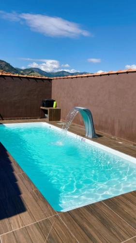 a swimming pool with a water fountain at Sítio metamorfose in Piranguçu