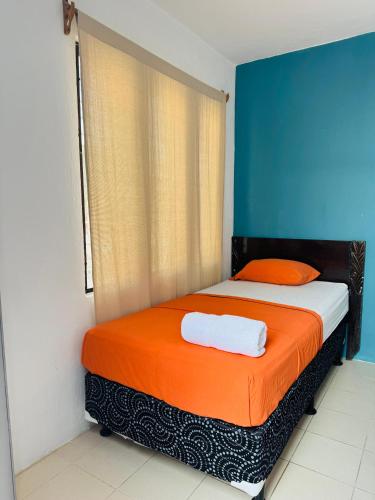 a bedroom with a bed with an orange blanket at Tikal Sunrise House in Flores