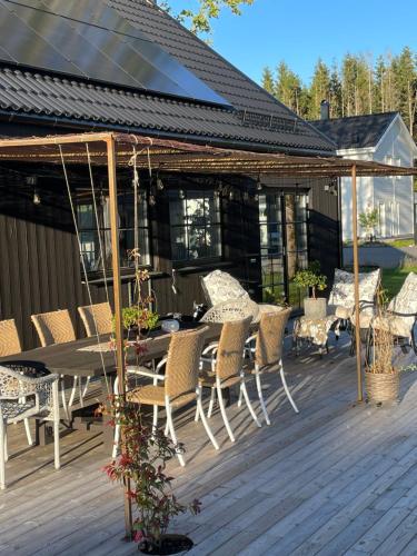 a patio with a table and chairs on a deck at Villa Golfgatan 32 Vintrosa Lanna in Vintrosa