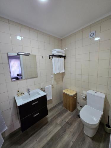 a bathroom with a toilet and a sink at Cozy Dot Apartment in Ponta Delgada