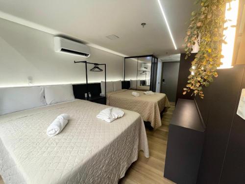 PenhaにあるFlat à beira-mar Setai Edition - MyFlats Hospedagensのベッドが2つと鏡があるホテルの部屋