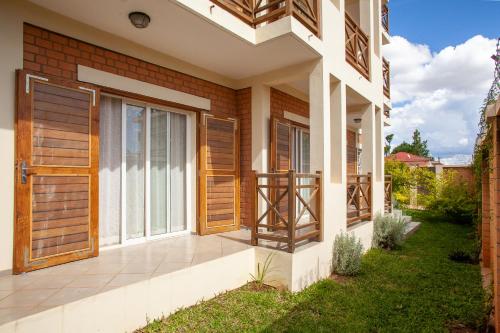 a house with wooden doors and a patio at LAMINA Appart in Antananarivo