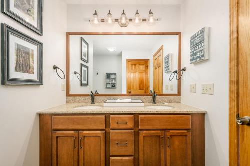ein Badezimmer mit zwei Waschbecken und einem großen Spiegel in der Unterkunft Reel Chill- 4 bedroom home with Dock, Swimspa, Hot tub! in Thayerville