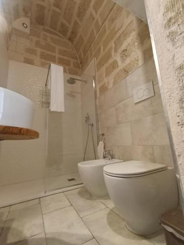 a bathroom with a white toilet and a shower at Antico Gelso in Polignano a Mare
