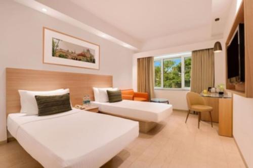 a hotel room with two beds and a couch at Hotel elegant NYSHAA A Family Hotel Airport PIckup & Drop Free in New Delhi