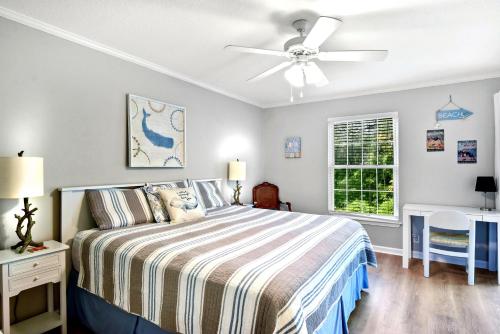 a bedroom with a bed and a ceiling fan at Salt Shack in Saint Simons Island