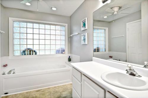 a white bathroom with a tub and a sink at Salt Shack in Saint Simons Island
