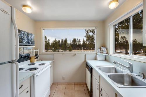 a kitchen with a sink and a large window at Sleeps 30, Riverfront, HotTub, PoolTable, DiscGolf in Three Rivers