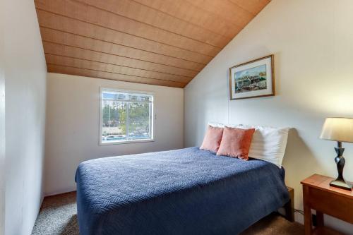 a bedroom with a blue bed and a window at Sleeps 30, Riverfront, HotTub, PoolTable, DiscGolf in Three Rivers